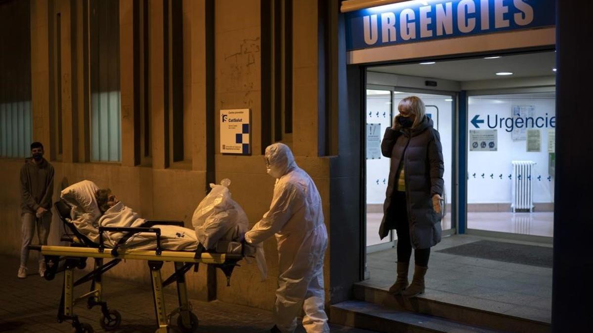 Coronavirus. Un paciente es llevado a una ambulancia desde un hospital de Barcelona