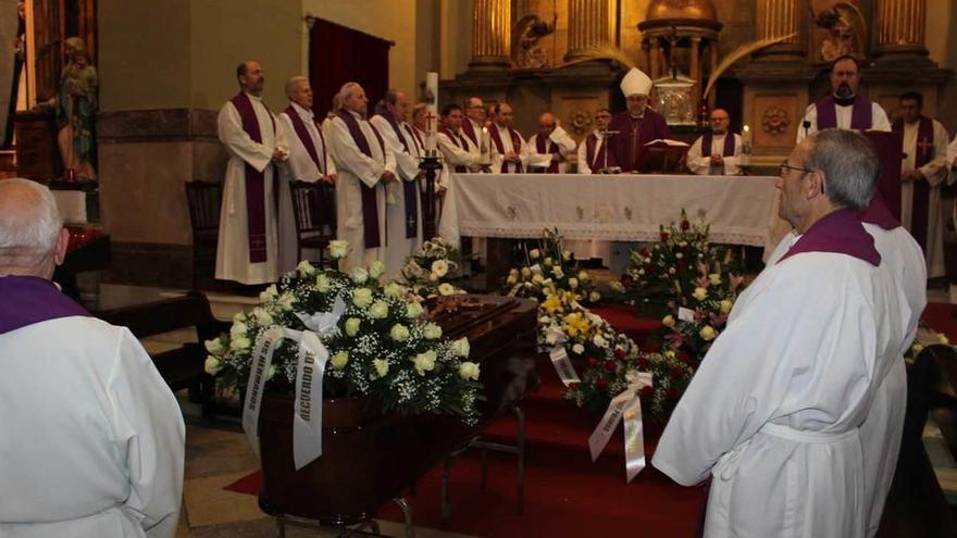 El féretro arropado ayer por los sacerdotes y el Arzobispo (tras el altar).