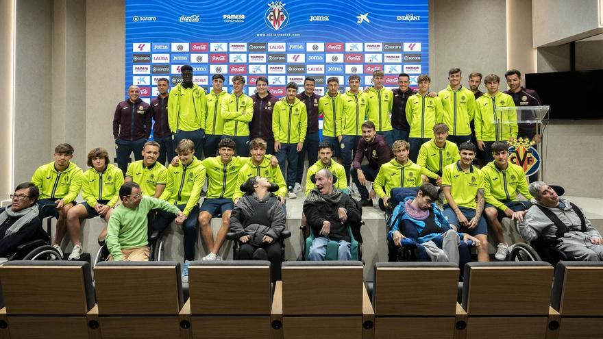 El equipo juvenil del Villarreal y usuarios de la Fundación Aspropace en la sala de prensa del Estadio de la Cerámica.