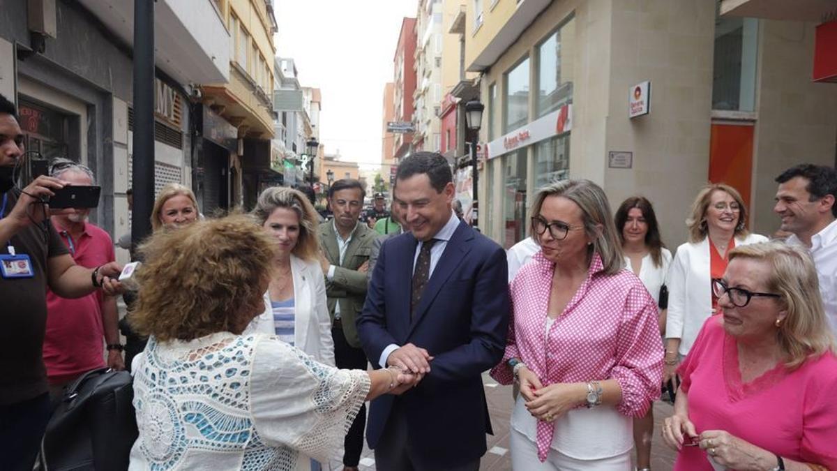 El presidente de la Junta de Andalucía y candidato a la reelección, Juanma Moreno (c), conversa con varias mujeres durante la visita realizada a la Línea de la Concepción (Cádiz).