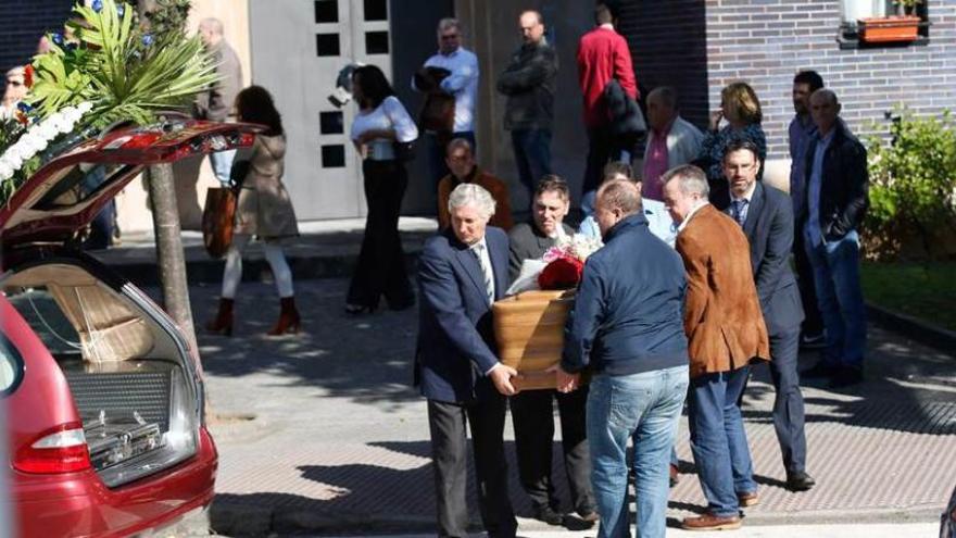 Asistentes al funeral, ayer, en la iglesia de San Juan de Ávila, portando uno de los féretros.