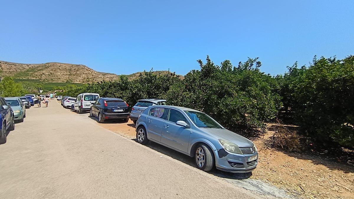 Coches aparcados en el camino rural que accede al río en El Reguer de Antella.
