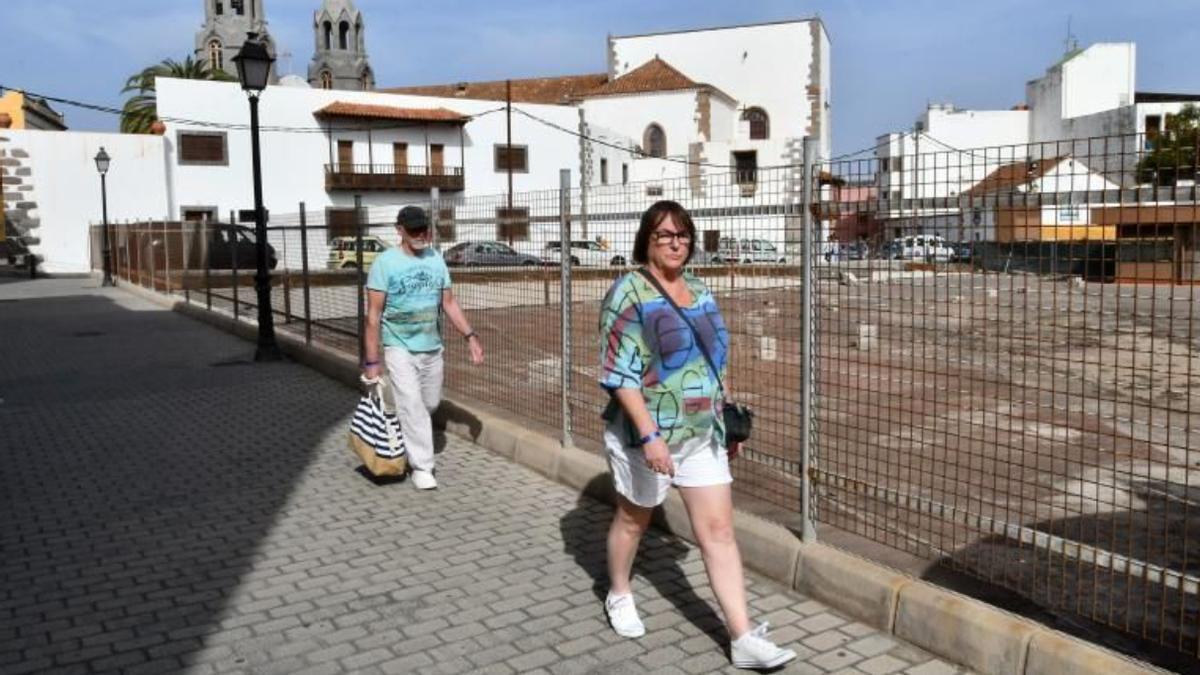 Dos viandantes junto al parking subterráneo de San Juan, en Telde.