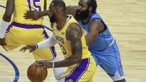 Harden, visiblemente pasado de peso, intenta frenar la entrada a canasta de Lebron James