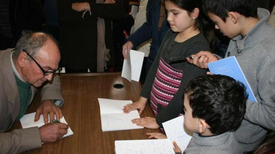 Alberto Calvín firma autógrafos de su libro a los escolares taramundeses.
