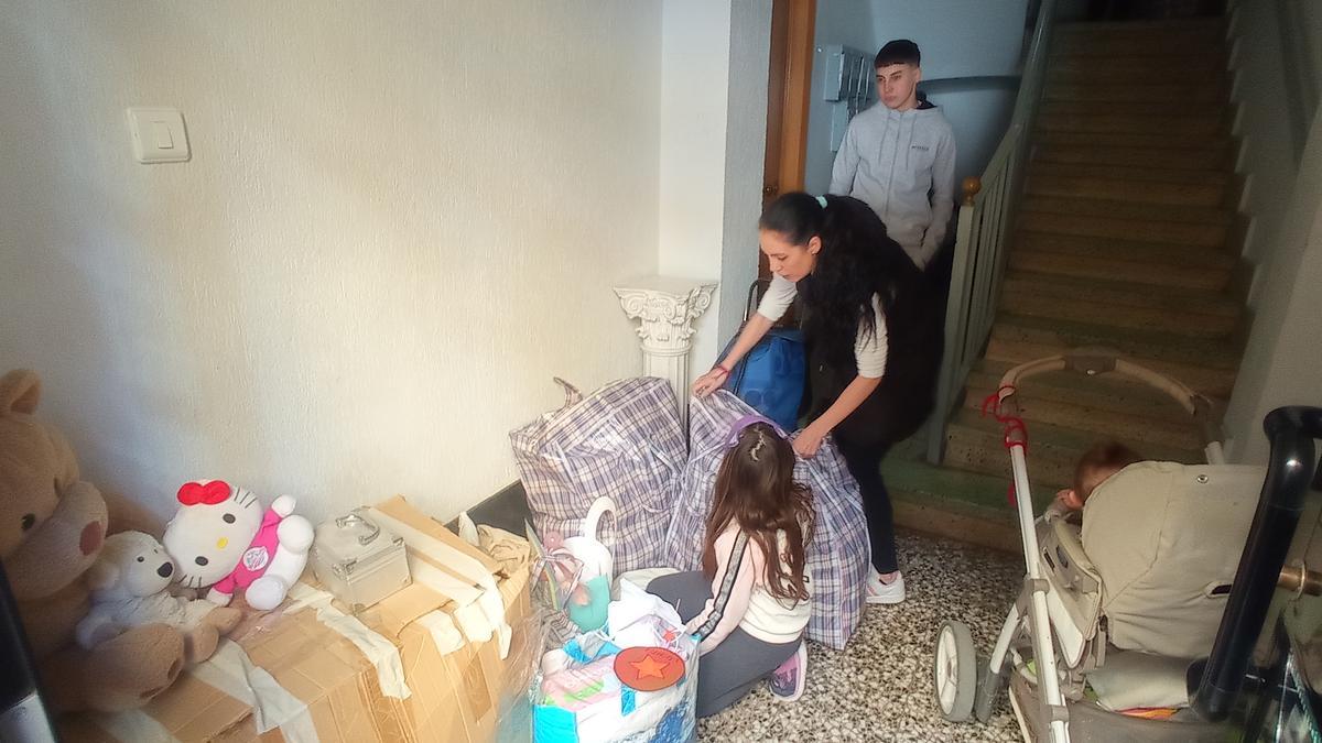 María junto a sus hijos, baja sus pertenencias al patio de la casa donde ha sido desahuciada.