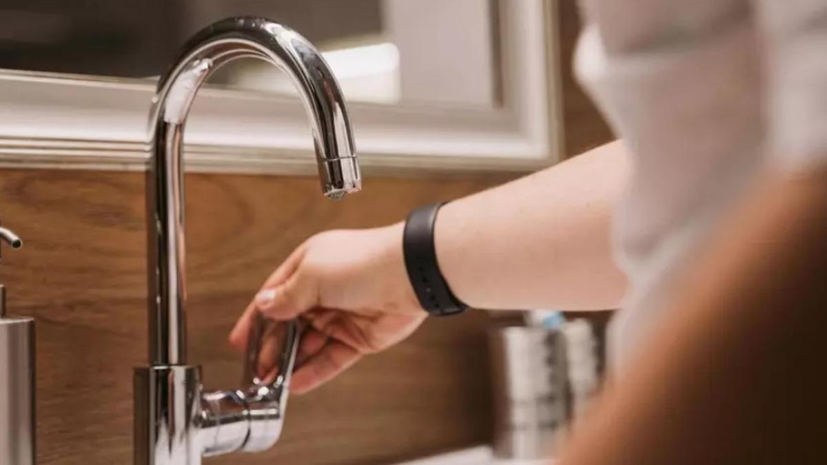 Una imatge d'arxiu d'una persona obrint una aixeta.