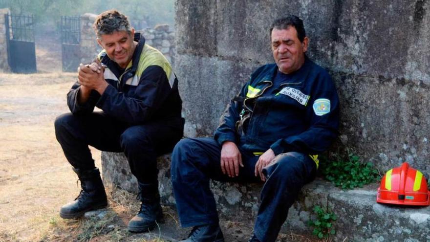 Dos bomberos descansan en Hoyos (Cáceres).
