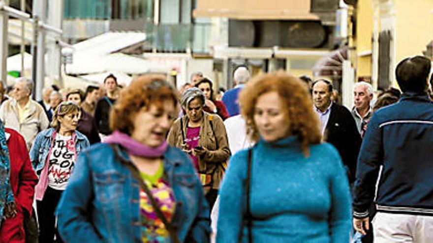 Turistas caminan por el paseo de Las Canteras.