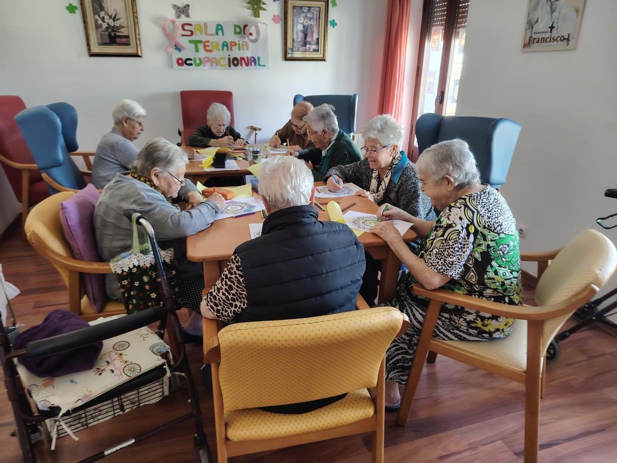 Un grupo d epersonas mayores realiza una actividad de manualidades.