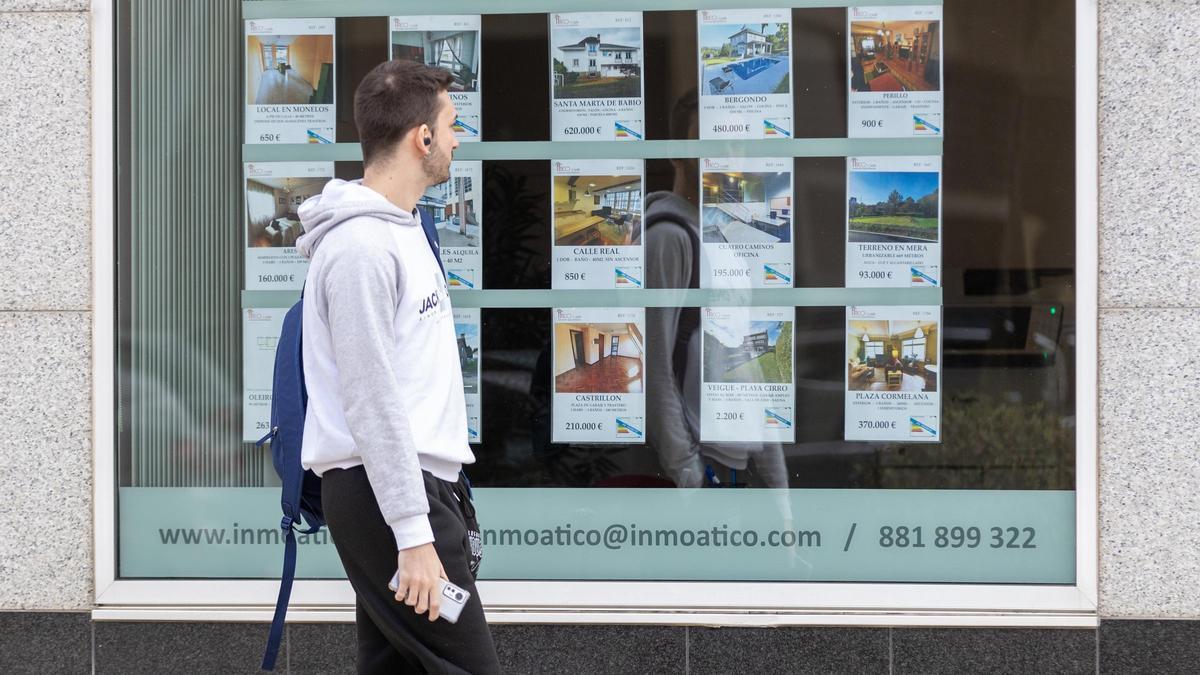 Un joven, delante del escaparate de una inmobiliaria en A Coruña.
