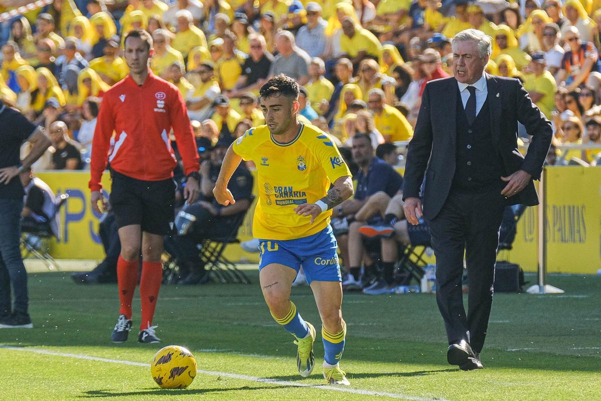 Alberto Moleiro conduce el balón bajo la mirada de Ancelotti.