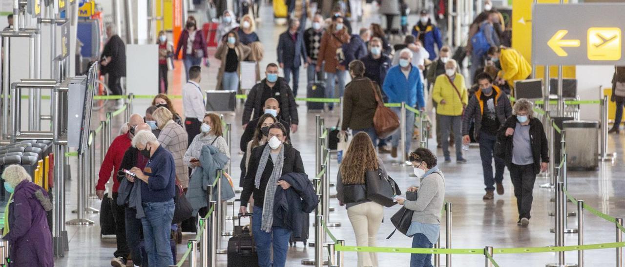 Pasajeros accediendo a la zona de salidas del aeropuerto el pasado 23 de diciembre, víspera de la Navidad. | ALEX DOMÍNGUEZ