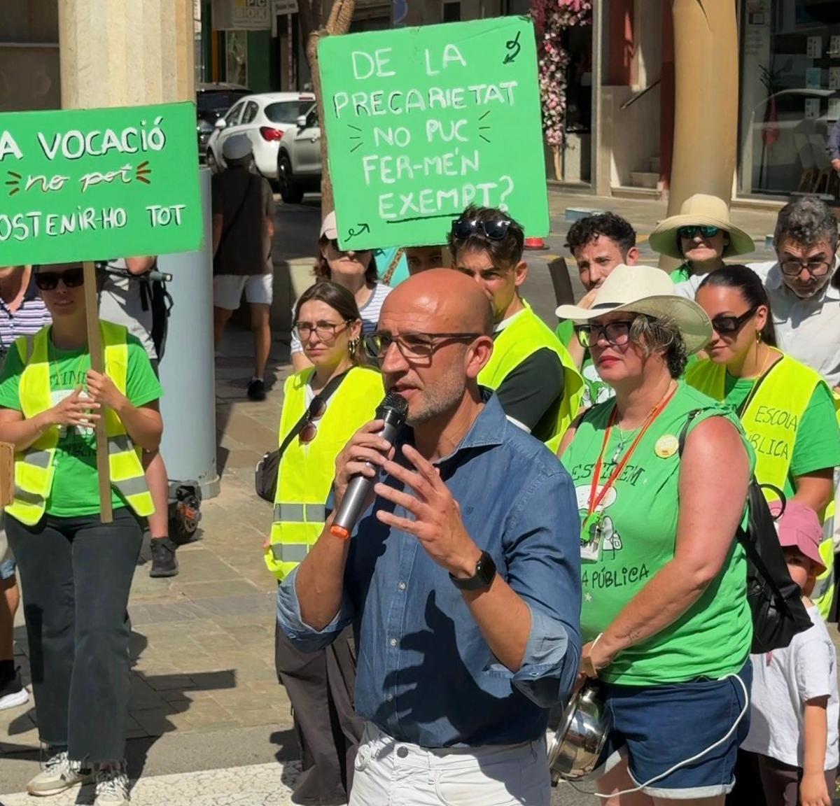 Un momento de la protesta con el concejal micrófono en mano dando unas explicaciones que no han convencido a los docentes