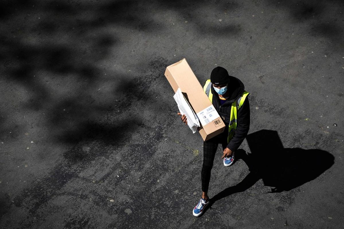 Un repartidor de Amazon en su camino a hacer una entrega en París, en las semanas de confinamiento.