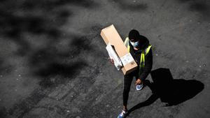 Un repartidor de Amazon en su camino a hacer una entrega en París, en las semanas de confinamiento.