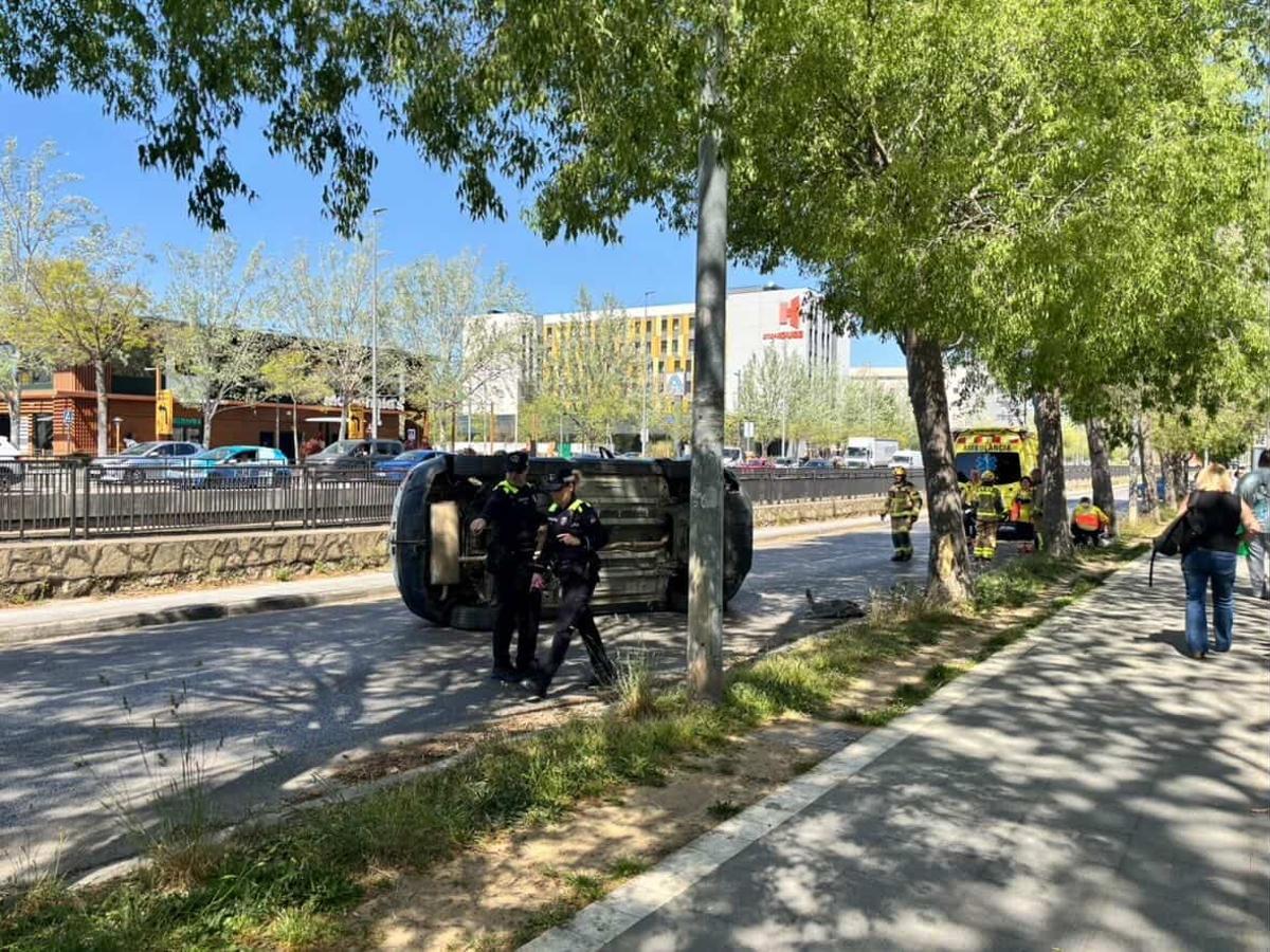 El vehicle bolcat i els serveis d'emergència a l'avinguda Josep Tarradellas de Girona.