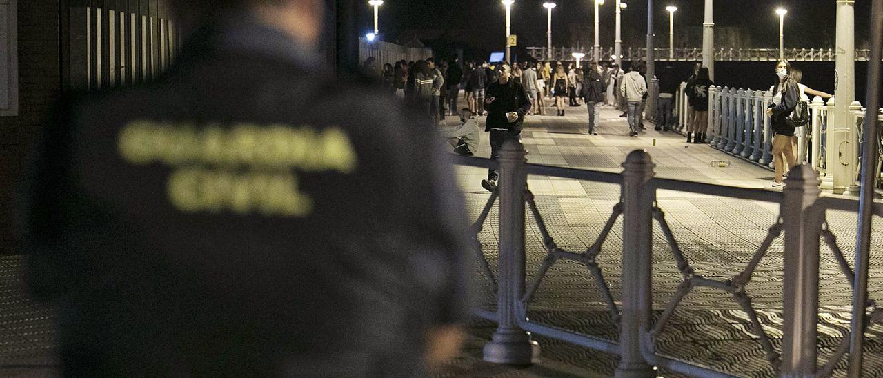 Un guardia civil vigila en la madrugada del viernes al sábado el paseo  marítimo de Salinas. | |  RICARDO SOLÍS