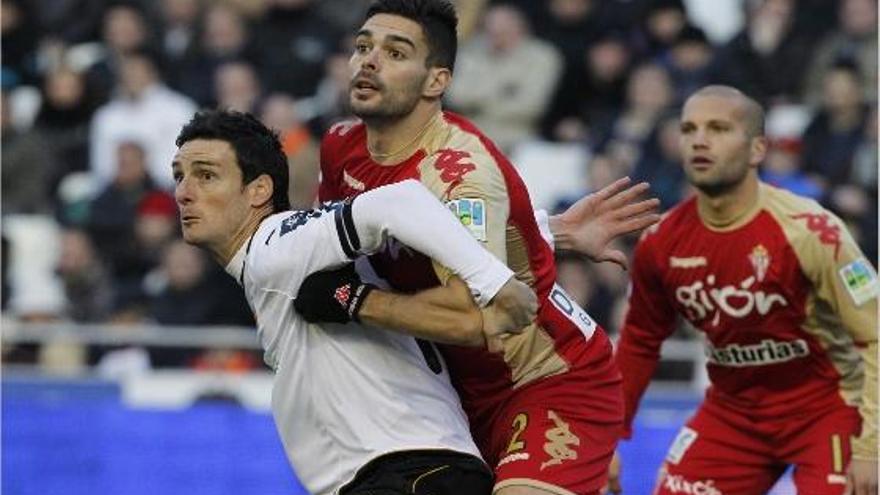 Aduriz trata de rematar un balón mientras Botía, al que el Valencia pretende para la próxima temporada, lo sujeta.