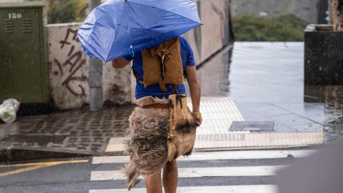 Una mujer se protege de la lluvia con un paraguas.