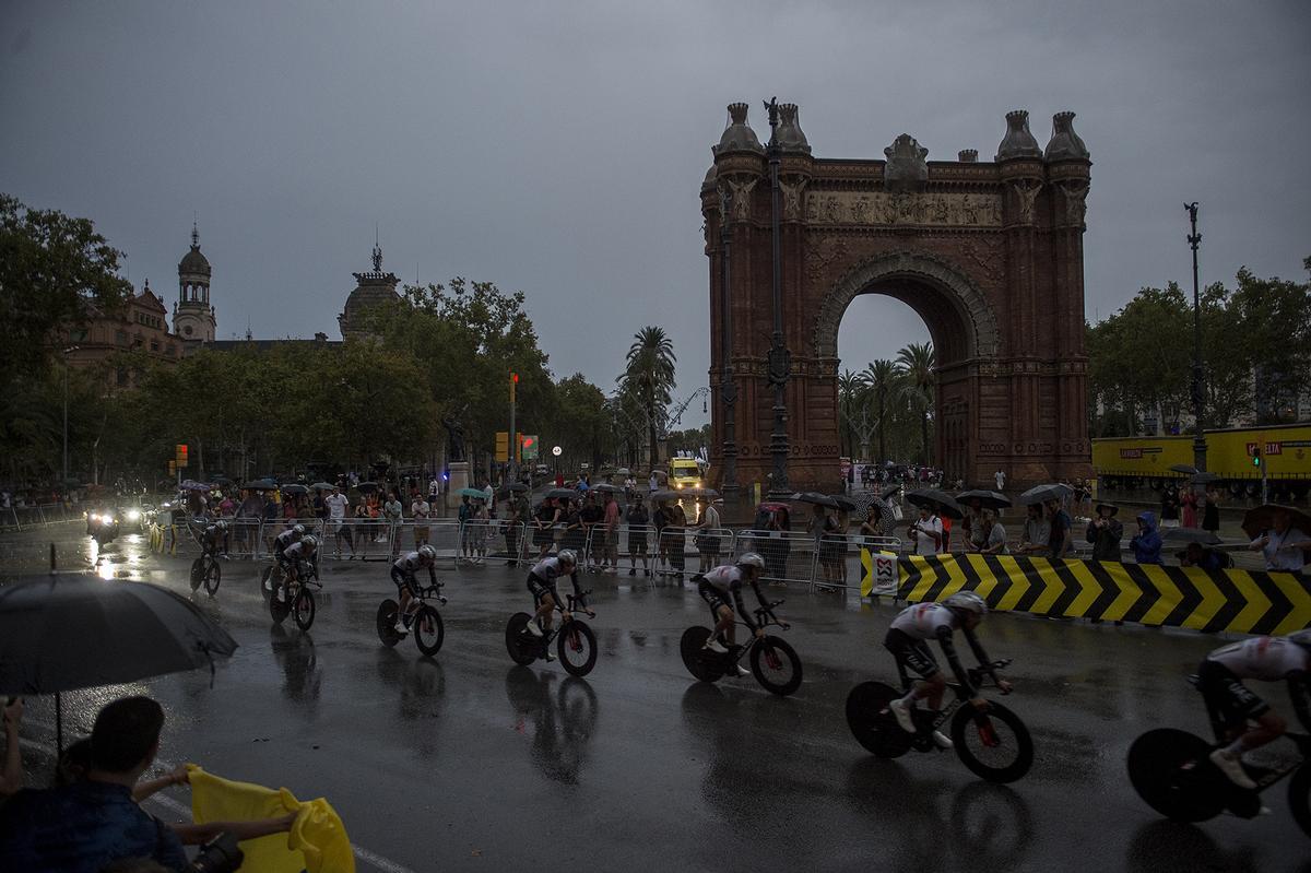 Ciclismo heróico en Barcelona. La tormenta y la falta de luz marcan una contrarreloj de la Vuelta que gana por sorpresa el equipo DSM. En la imagen, el equipo UAE Emirates pasa junto al Arc de Triomf en la Vuelta a España