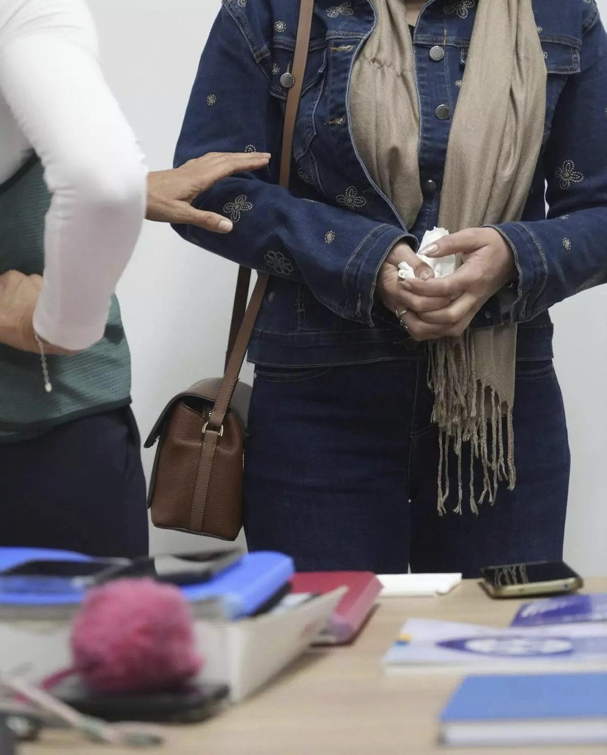Andrea, víctima de violencia de género, sujeta un pañuelo con fuerza.