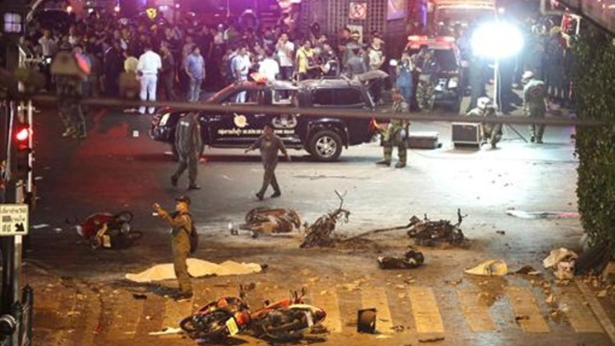 Un policía toma imágenes de los desperfectos por la detonación en Bangkok.