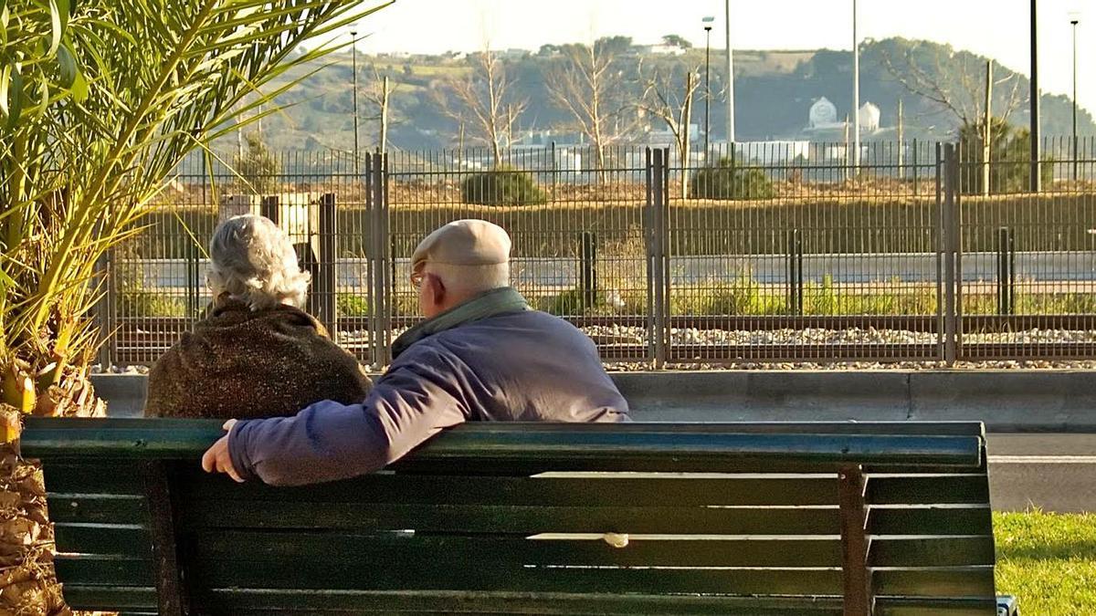 Una pareja de mayores, sentados en un parque