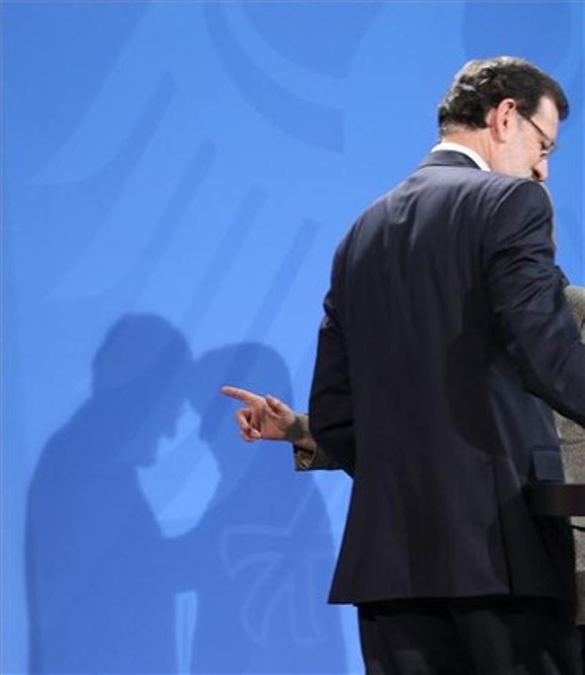 Les ombres de Rajoy i Merkel, durant la seva roda de premsa de dilluns, a Berlín.