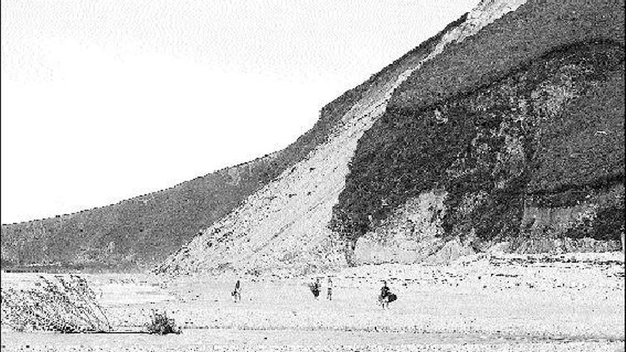Bañistas, ayer, pasean por el arenal, cerca del argayu, en Llanes.