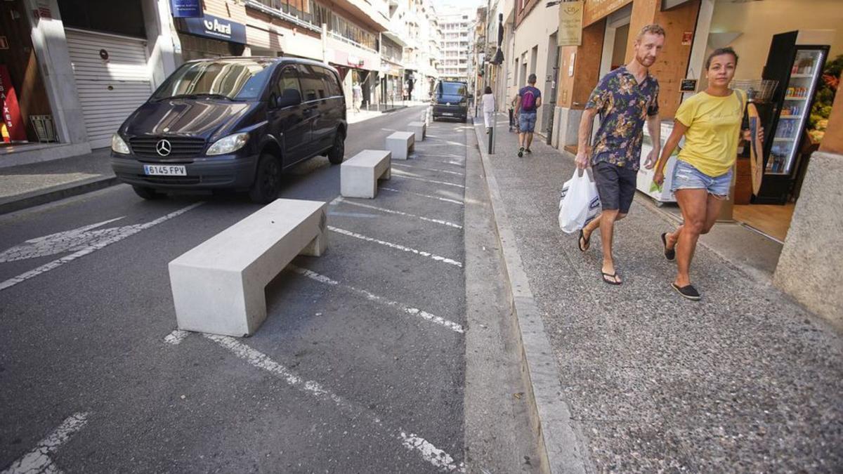 Bancs al carrer Juli Garreta en espais per aparcar motos. | MARC MARTÍ