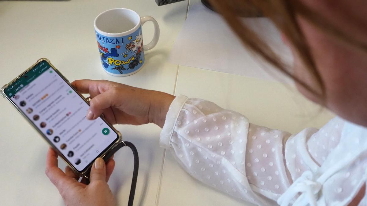 Una mujer mira los mensajes de Whatsapp de su móvil Una mujer mira los mensajes de Whatsapp de su móvil