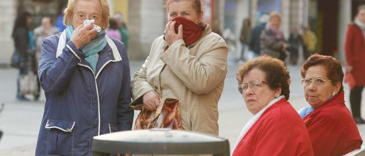 Dos mujeres se protegen las vías respiratorias el día de abril de 2017 en el que una avería en las baterías de coque generó una nube tóxica.