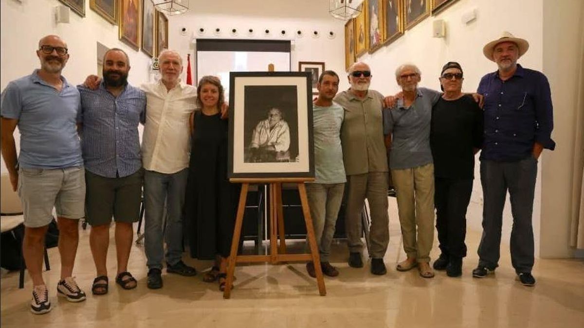 Familiares y amigos de la escritora posan junto al retrato de Xesca Ensenyat en la sala de plenos.