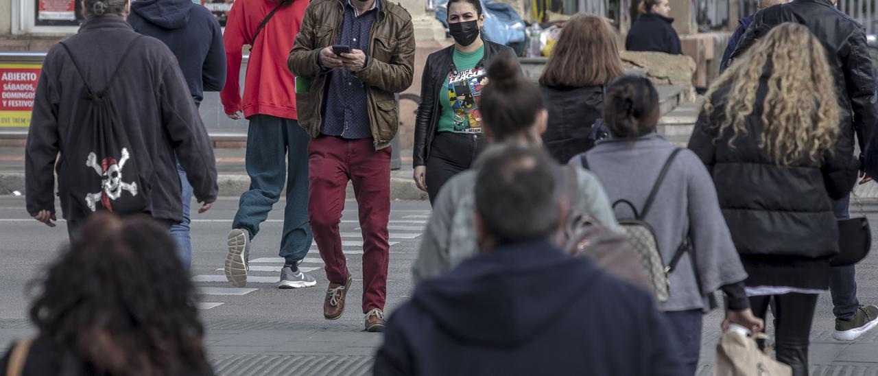 Ciudadanos con mascarilla cruzan las Avenidas a la altura de la plaza de España