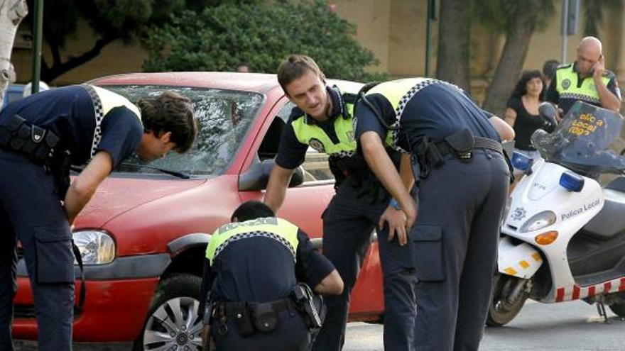 Agentes de la Policía Local, ayer, inspeccionando el coche que atropelló a la mujer.