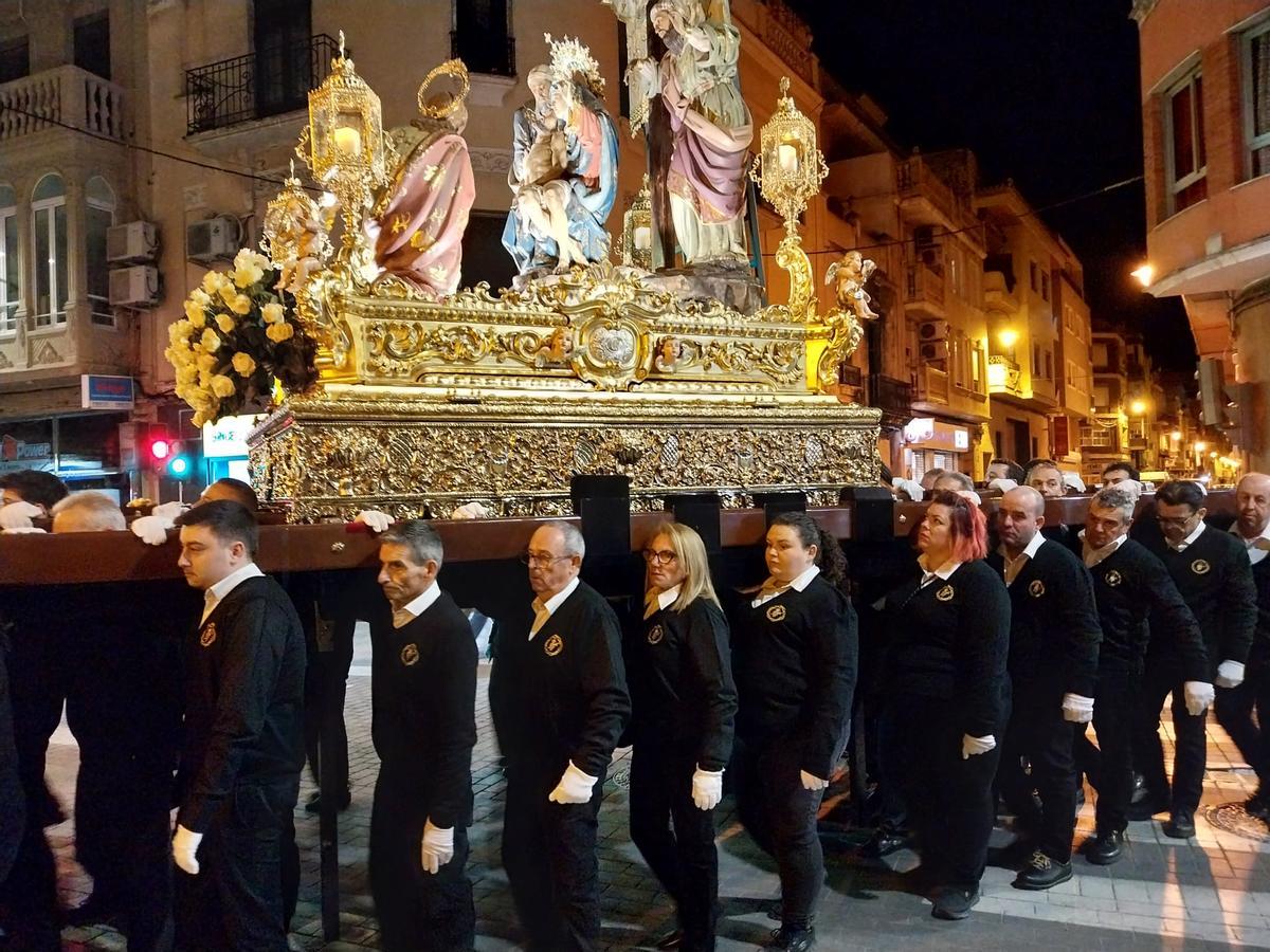 Mujeres y hombres cargan la imagen de La Dolorosa en Alzira.