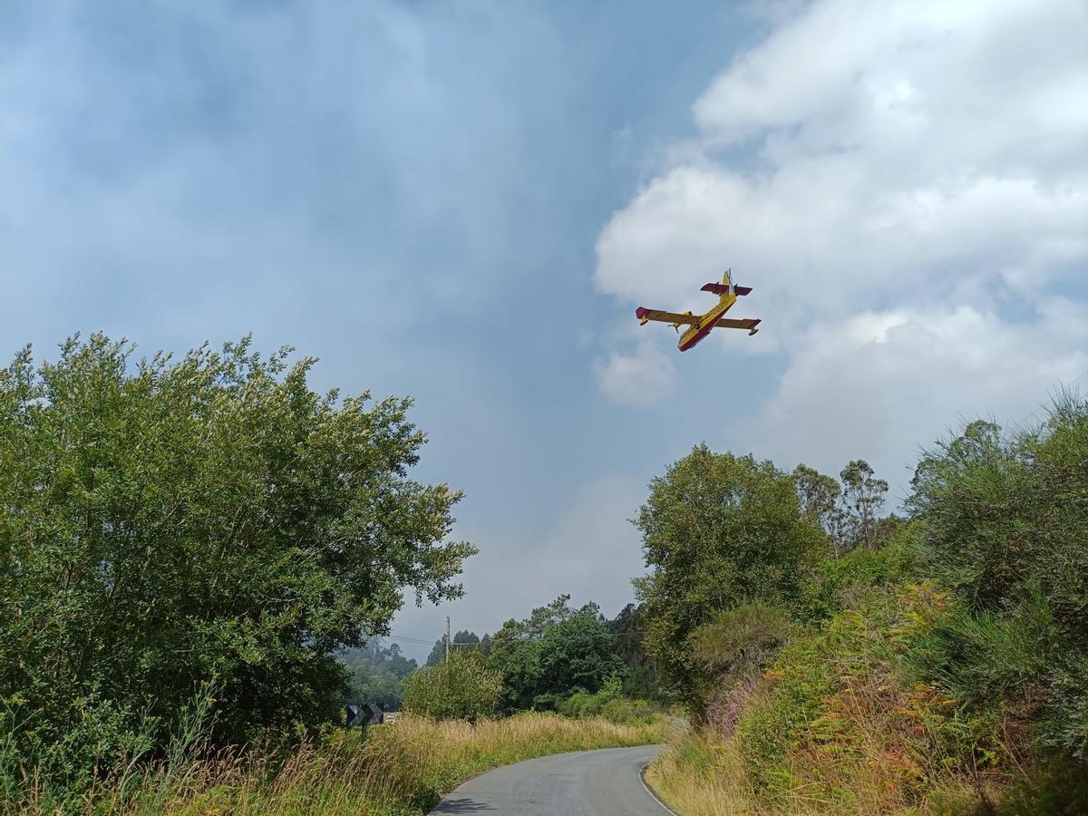 Avión del servicio de extinción trabajando en la zona de Nande, en Laxe.