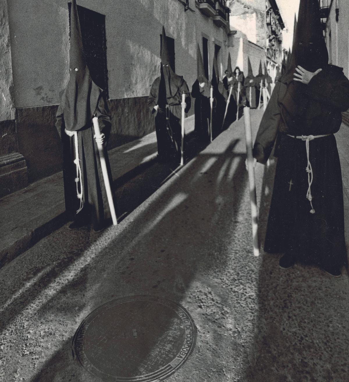 Las sombras de la cruz de guía de la hermandad franciscana se proyecta sobre la calle Lineros.