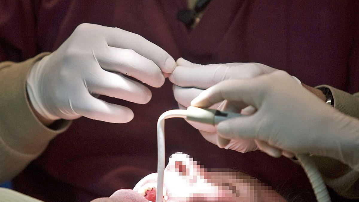 Un dentista atiende a un paciente en su consulta. | Reuters