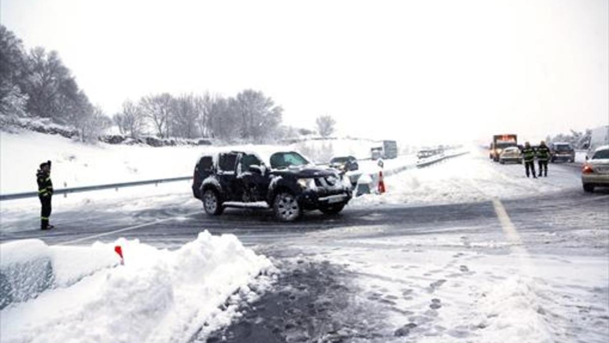 Agentes de la policía ayudan el domingo a los vehículos atrapados en la AP-6 por la tormenta de nieve.