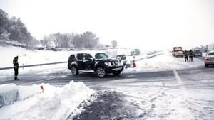 Agentes de la policía ayudan el domingo a los vehículos atrapados en la AP-6 por la tormenta de nieve.