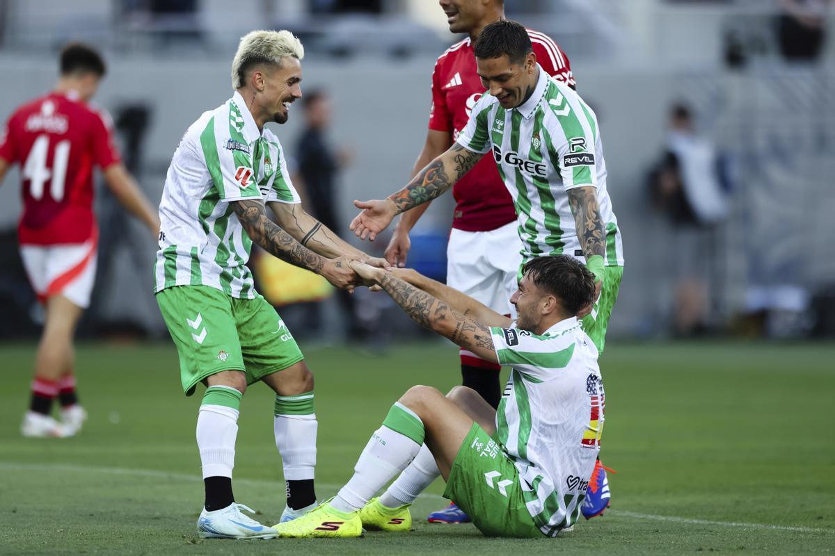 Iker Losada, del Real Betis, abajo a la derecha, es felicitado por Rodri Sánchez, a la izquierda, y Chimy Ávila tras marcar un gol contra el Manchester United durante la primera parte de un partido de fútbol el miércoles 31 de julio de 2024, en San Diego.