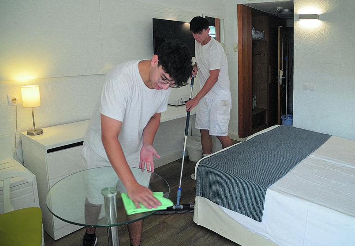 Los camareros de piso Mustafá Lamtiri quita el polvo y Joan Marc Martín repasa el suelo en una habitación del hotel Morito, en Cala Millor, Mallorca |
