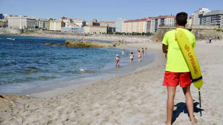 Un socorrista vigila la actividad de los bañistas en la playa de Riazor.