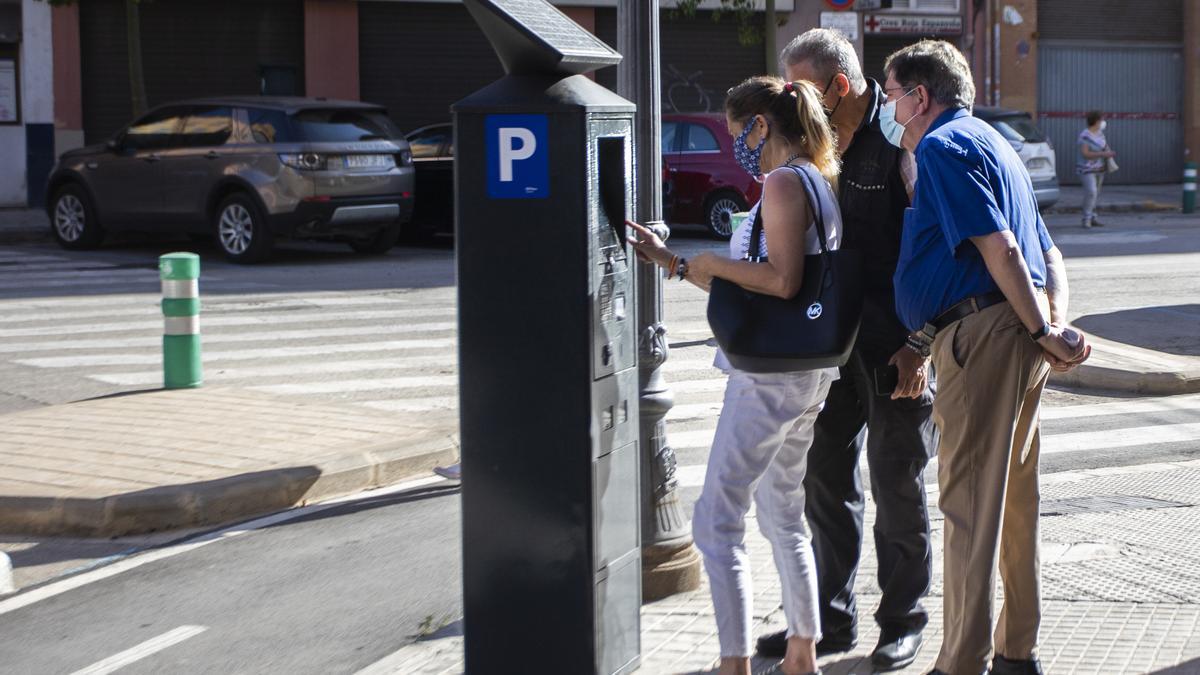 Tres usuarios pagan en el parquímetro, con los nuevos horarios de la ORA.