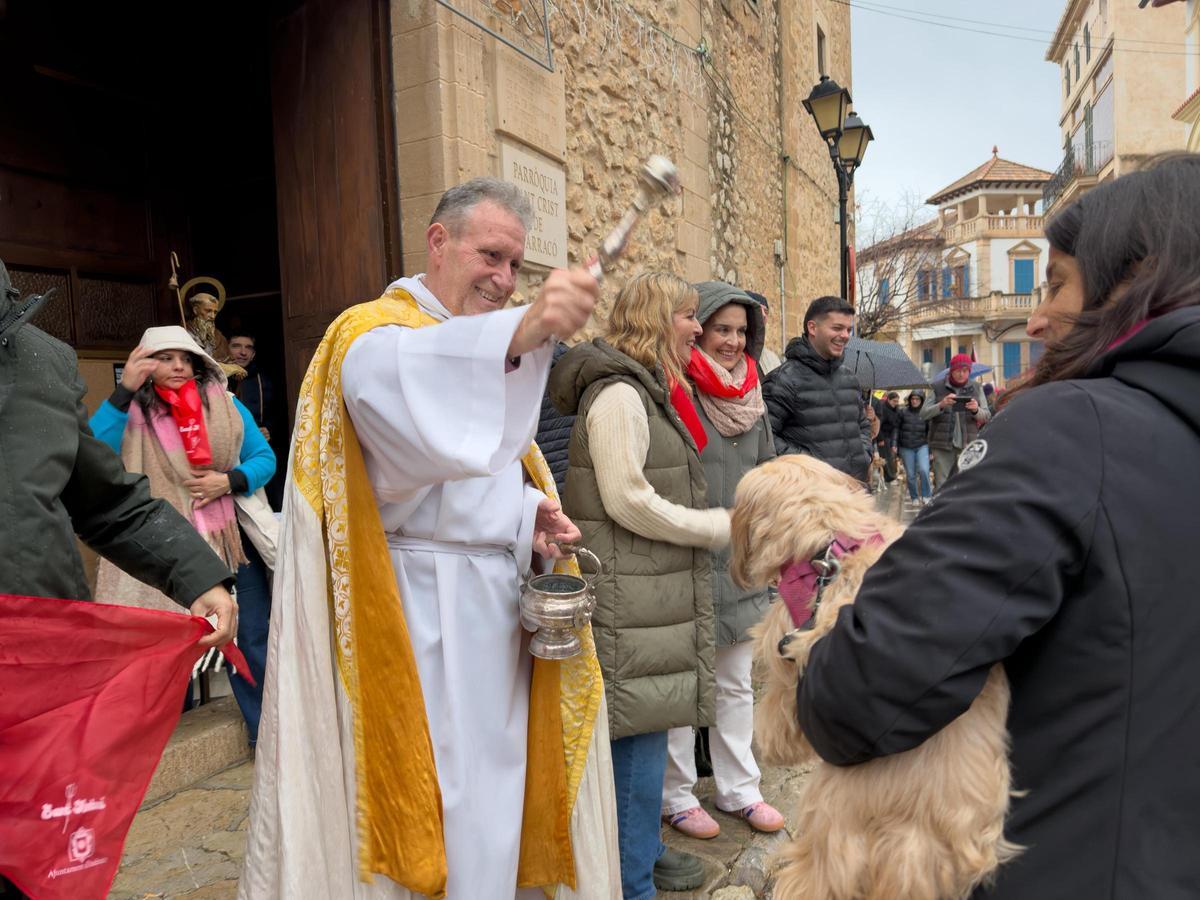 El rector mossèn Joan Bordoy bendice a un perro.