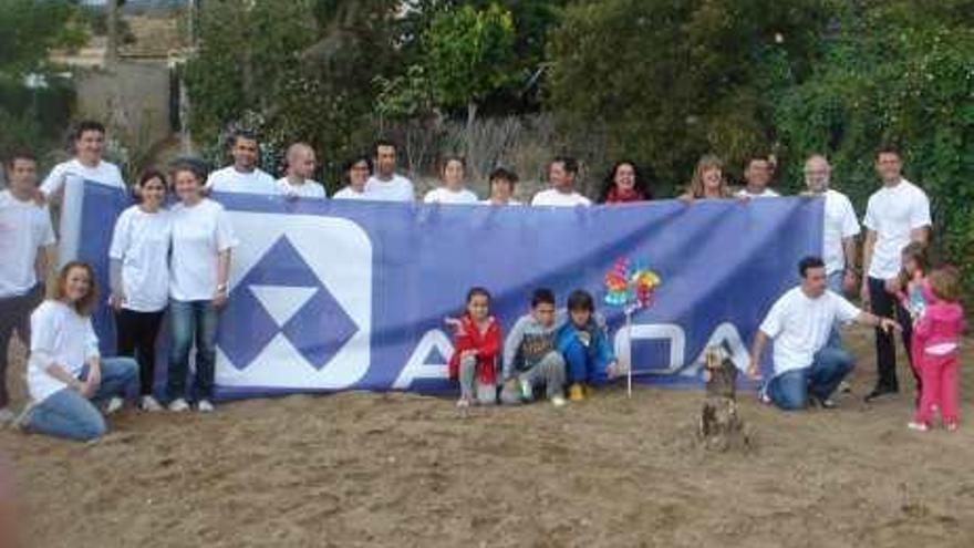 Voluntarios, padres y niños ante el futuro huerto.