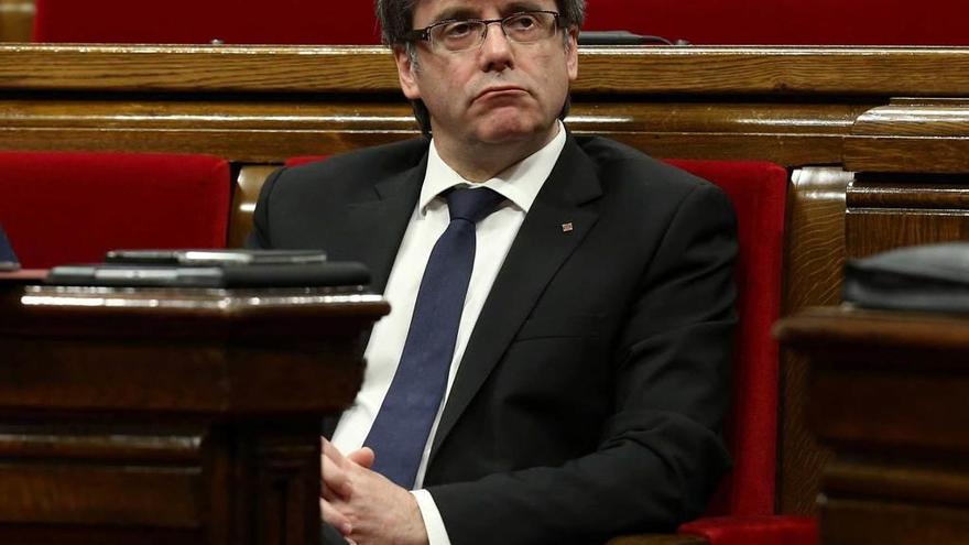 Puigdemont, sentado en su escaño del Parlament.