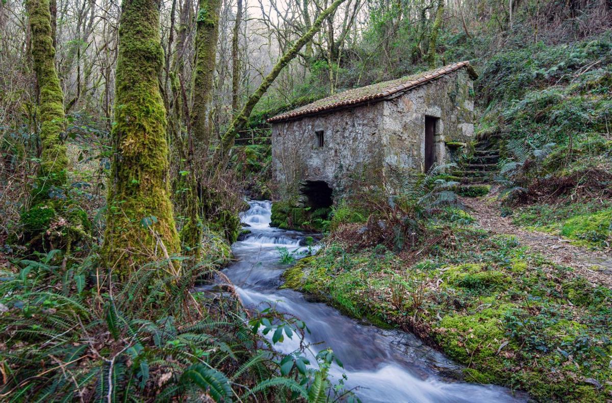 Arriba, la central hidroeléctrica de Salouzáns. A la izquierda, señalización realizada por el cantero y escultor Manuel López, responsable de la restauración de la ruta y de la decoración y funcionamiento de sus molinos. Debajo, más obras de López en el lugar. | FOTOS: JUAN CARLOS ASOREY